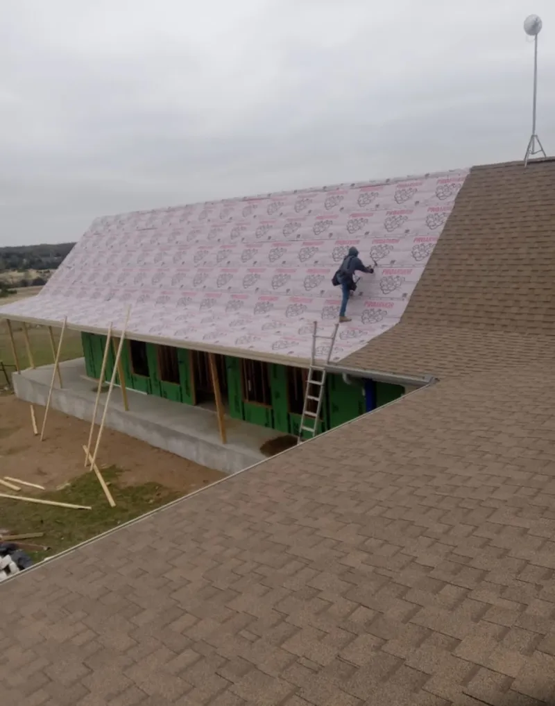 Worker preparing underlayment for a metal roof installation in Westchase